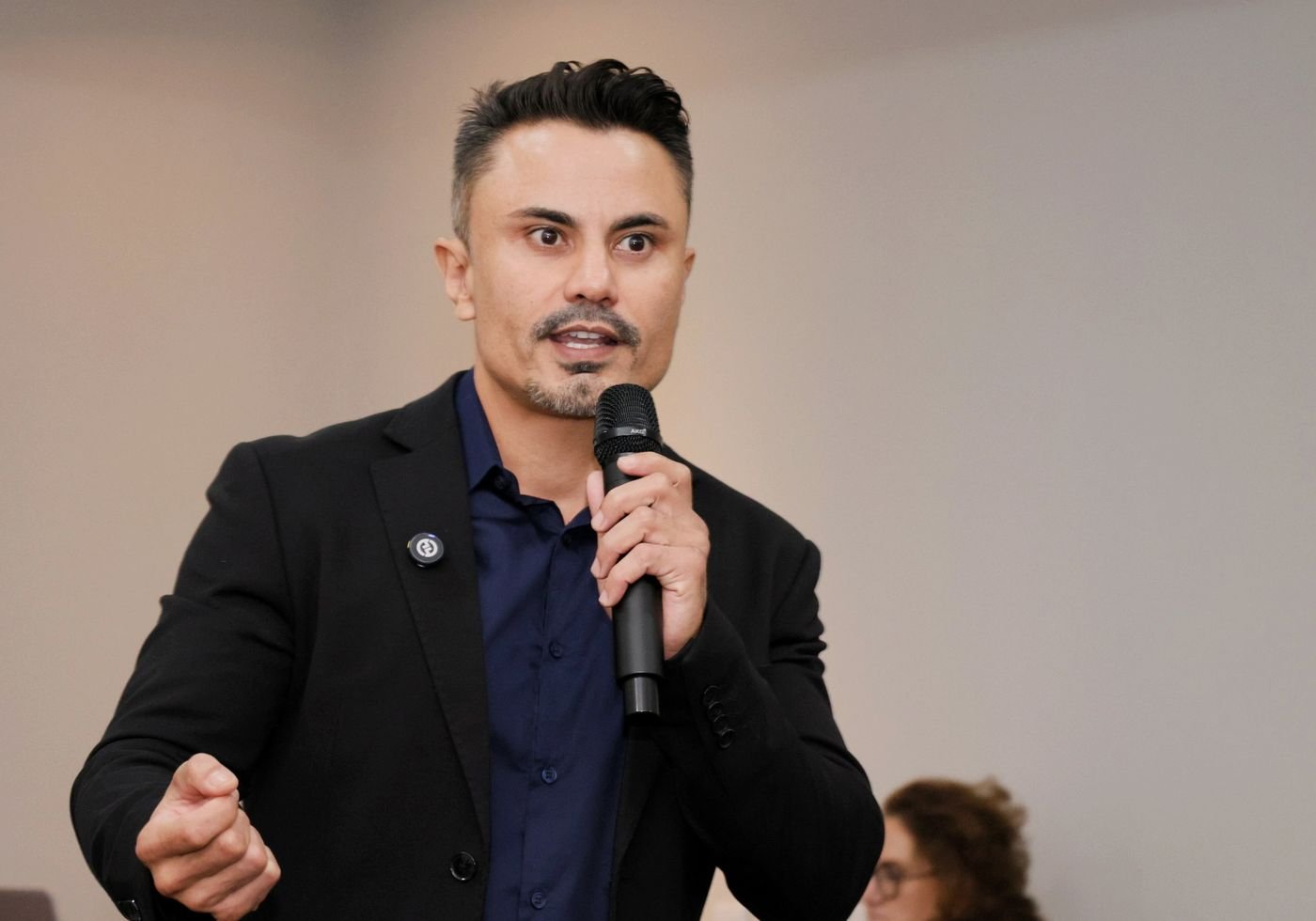 Fabiano Moraess falando ao microfone para a plateia