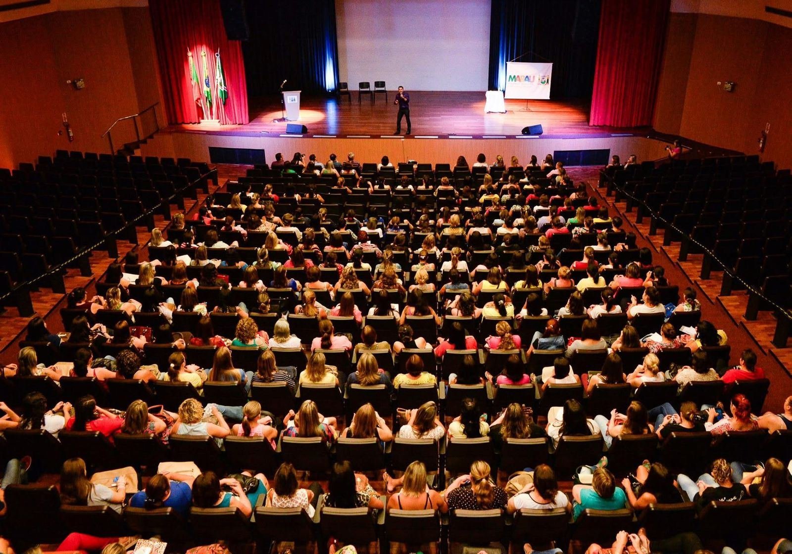 Fabiano Moraess no palco, falando para um teatro lotado em Marau, Rio Grande do Sul